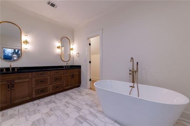 full bathroom featuring double vanity, a freestanding tub, a sink, and visible vents