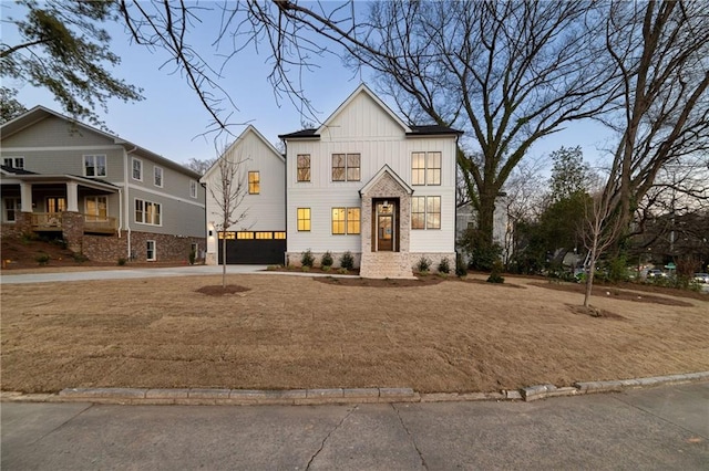 modern farmhouse featuring a garage, driveway, and board and batten siding