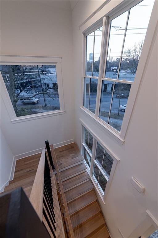 stairway with baseboards and wood finished floors