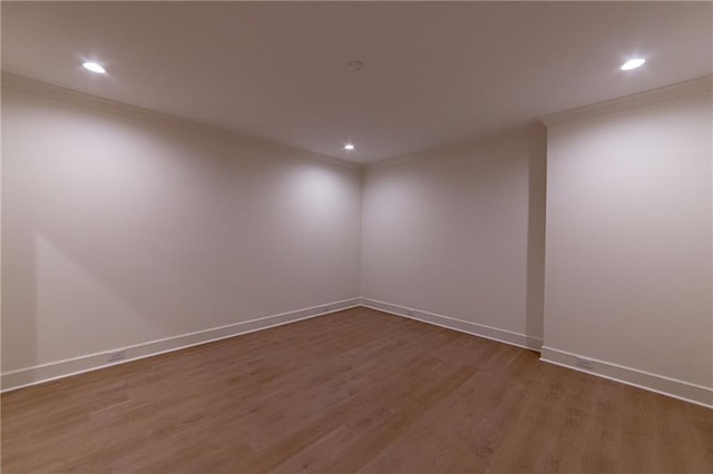 spare room featuring ornamental molding, recessed lighting, baseboards, and wood finished floors