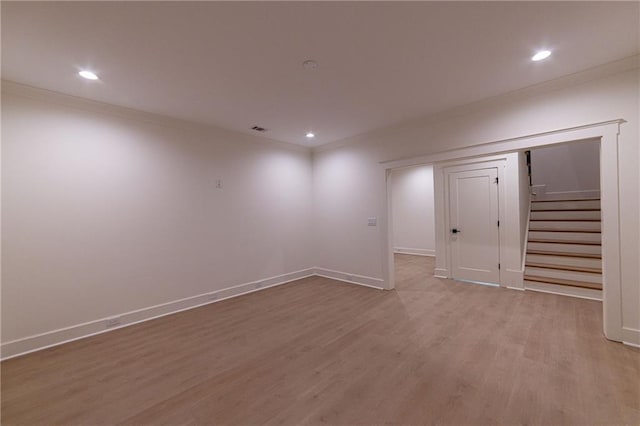 below grade area with baseboards, ornamental molding, wood finished floors, stairs, and recessed lighting