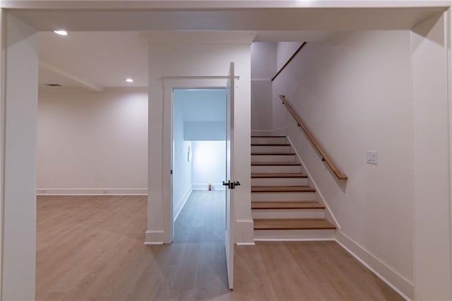 stairs featuring baseboards, wood finished floors, and recessed lighting