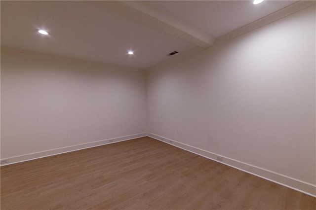 empty room with beam ceiling, recessed lighting, visible vents, dark wood-type flooring, and baseboards