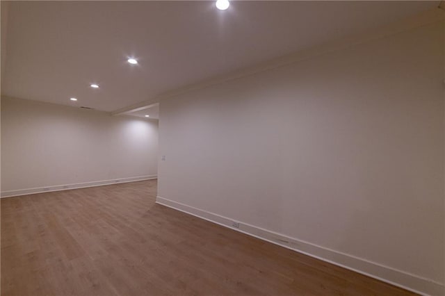 unfurnished room with baseboards, wood finished floors, and recessed lighting