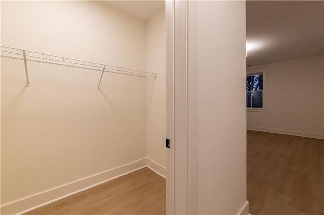 laundry area featuring light wood-style flooring and baseboards