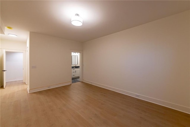 spare room with light wood-style flooring and baseboards