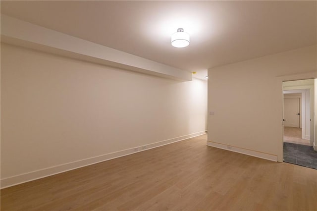 spare room with wood finished floors and baseboards