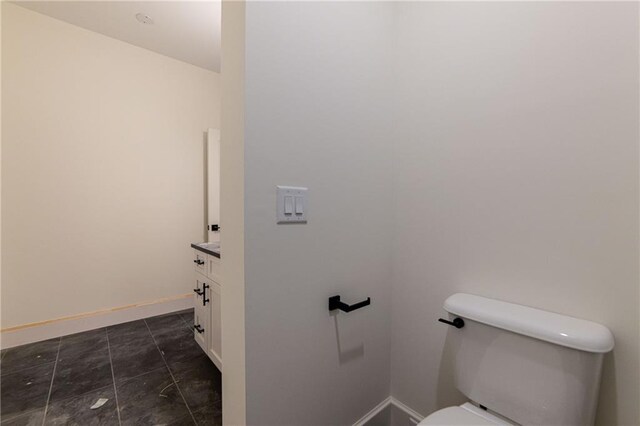 bathroom with vanity, toilet, and baseboards