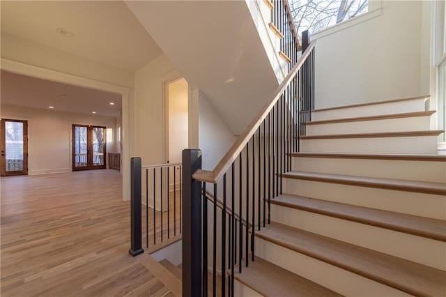 staircase featuring recessed lighting, baseboards, wood finished floors, and french doors