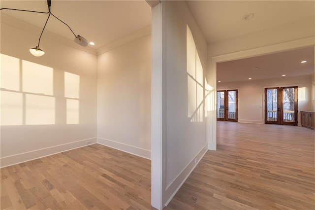 unfurnished room featuring french doors, wood finished floors, and baseboards