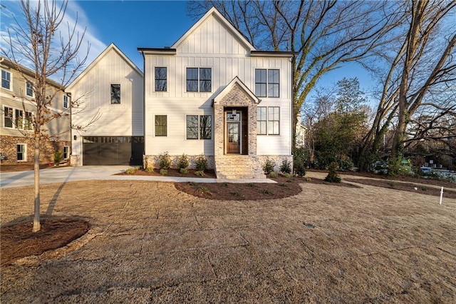 modern farmhouse with board and batten siding, concrete driveway, and an attached garage