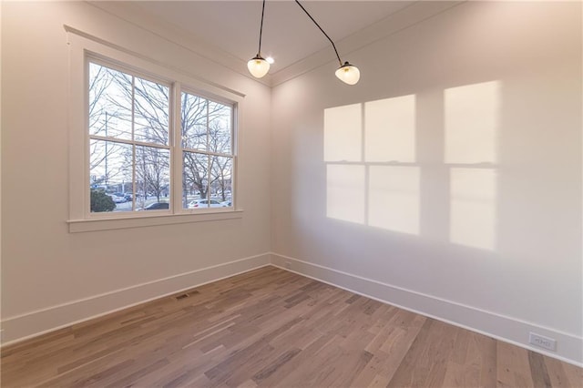 unfurnished room featuring lofted ceiling, light wood-style floors, visible vents, and baseboards