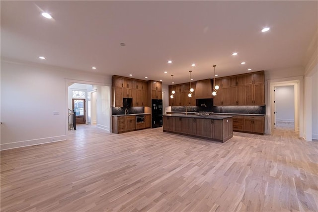 kitchen with open floor plan, tasteful backsplash, and light wood finished floors