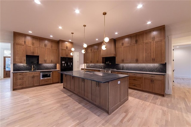 kitchen featuring custom exhaust hood, brown cabinetry, and a sink