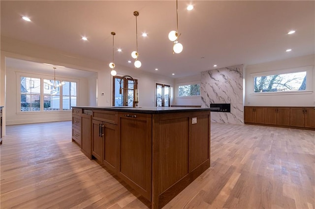 kitchen with a wealth of natural light, dark countertops, and a kitchen island