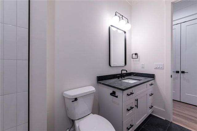 bathroom featuring tile patterned flooring, vanity, and toilet