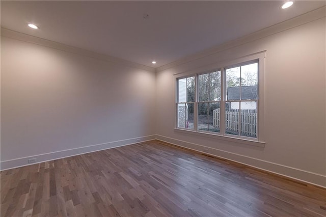 spare room with ornamental molding, recessed lighting, dark wood-type flooring, and baseboards