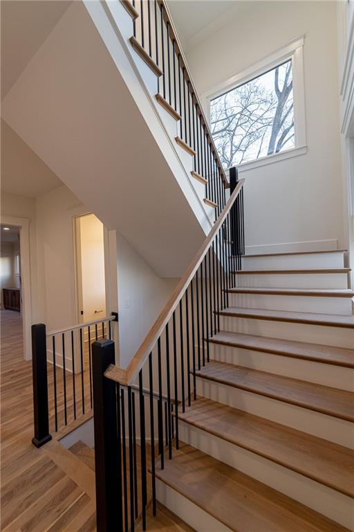 staircase featuring wood finished floors and a towering ceiling