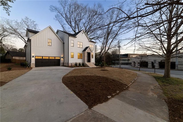 modern farmhouse style home featuring concrete driveway, board and batten siding, and an attached garage