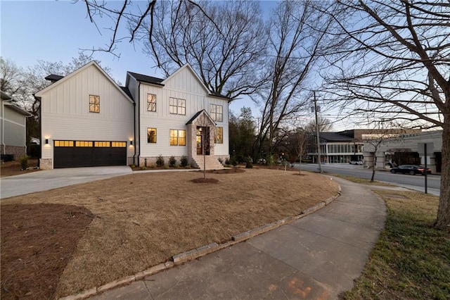 modern farmhouse style home with driveway, an attached garage, and board and batten siding