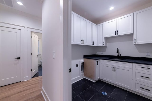 laundry area featuring cabinet space, baseboards, a sink, and recessed lighting