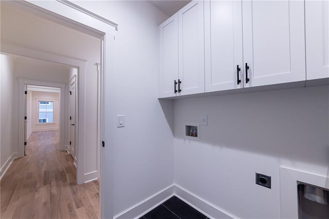 washroom featuring washer hookup, light wood finished floors, cabinet space, electric dryer hookup, and baseboards