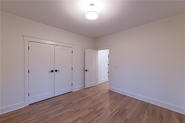 unfurnished bedroom with baseboards and wood finished floors