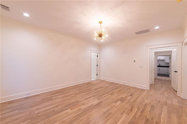 spare room featuring baseboards, visible vents, crown molding, light wood-type flooring, and a chandelier