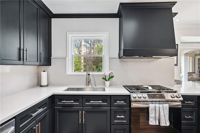 kitchen featuring ornamental molding, a sink, custom range hood, gas range, and light countertops