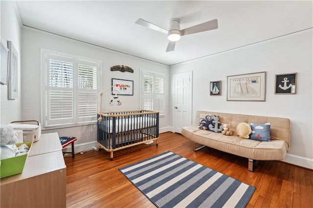 bedroom with baseboards, ornamental molding, and wood-type flooring