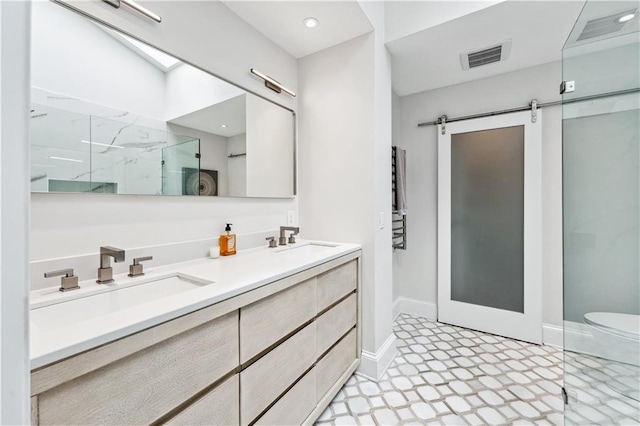 bathroom featuring double vanity, a marble finish shower, visible vents, and a sink