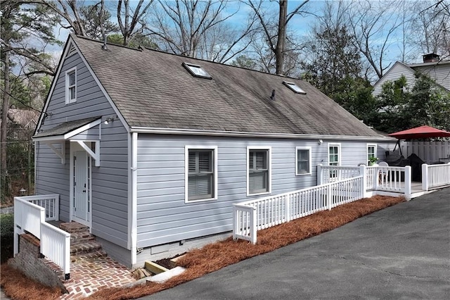 exterior space featuring roof with shingles