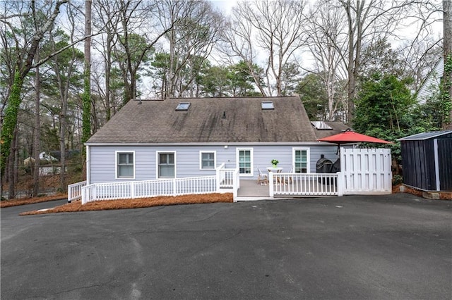 new england style home featuring roof with shingles