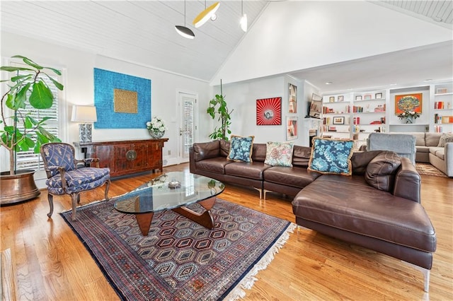 living area with built in shelves, wood finished floors, and high vaulted ceiling