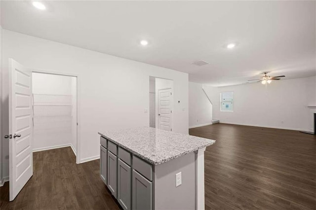 kitchen with gray cabinetry, dark hardwood / wood-style flooring, a center island, and ceiling fan