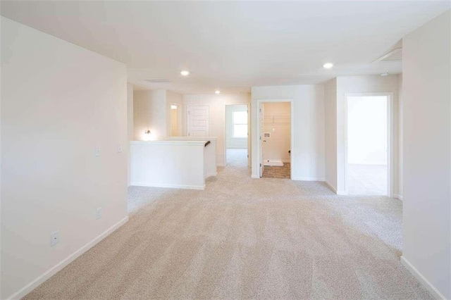 unfurnished room featuring light carpet