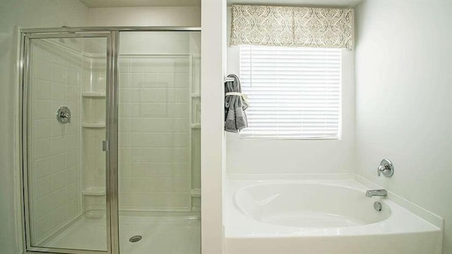 bathroom featuring separate shower and tub