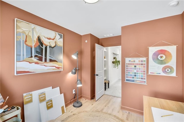 interior space featuring visible vents, baseboards, and wood finished floors