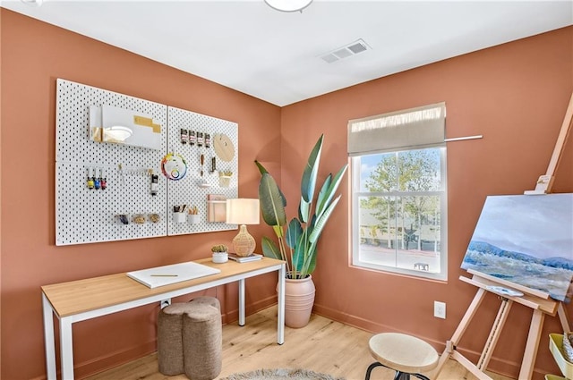 office area featuring visible vents, baseboards, and wood finished floors