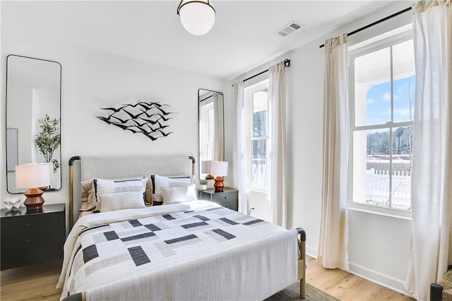 bedroom with visible vents, baseboards, and light wood-style floors