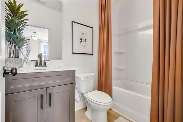 bathroom with vanity, toilet, visible vents, and shower / bath combo