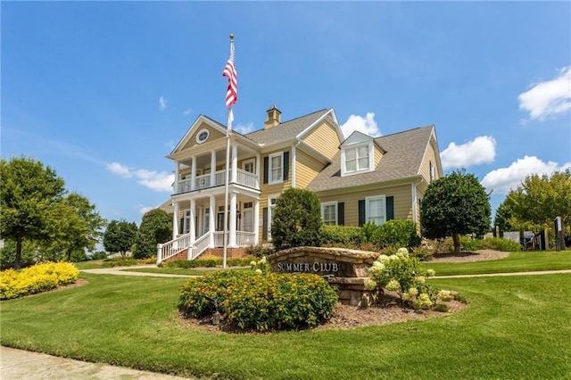 view of front of house featuring a front yard, a balcony, and a porch