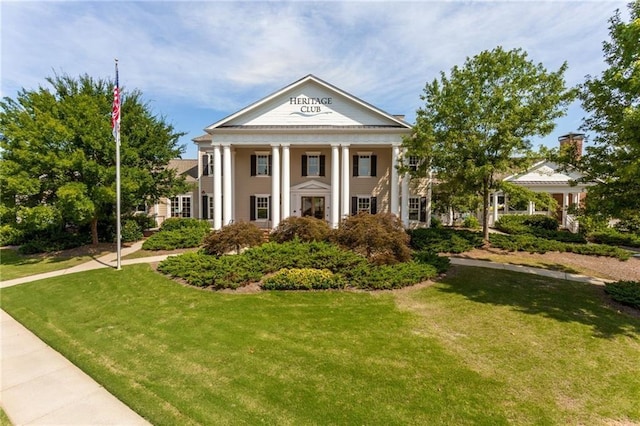 neoclassical home featuring a front yard