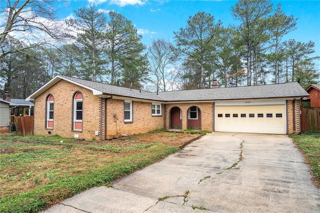 ranch-style home with a garage and a front lawn