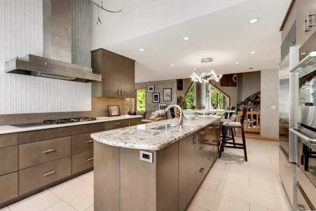 6525 Old Riverside Dr NW, Sandy Springs, GA 30328 - kitchen with recessed lighting, a sink, an inviting chandelier, wall chimney exhaust hood, and a large island with sink
