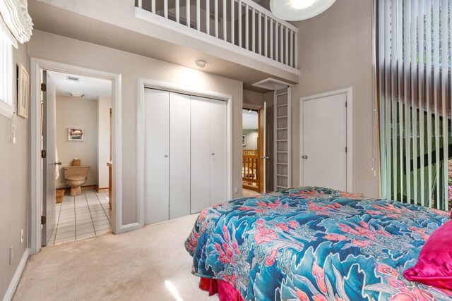6525 Old Riverside Dr NW, Sandy Springs, GA 30328 - tiled bedroom featuring a closet, carpet, baseboards, visible vents, and a towering ceiling