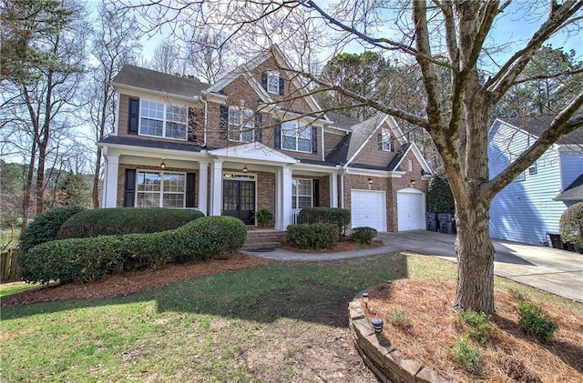 view of front facade with brick siding, a garage, driveway, and french doors