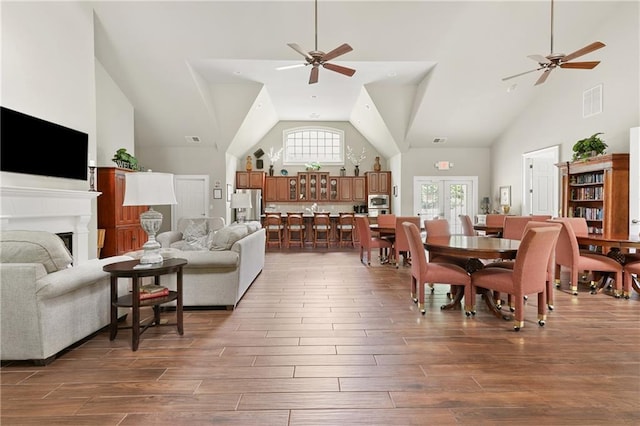 living room featuring a ceiling fan, high vaulted ceiling, wood finished floors, and a fireplace
