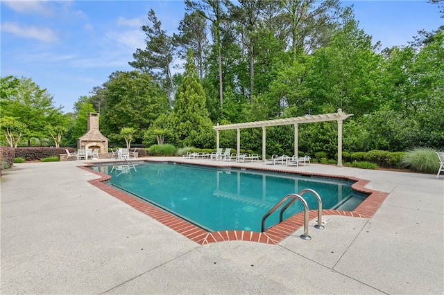 outdoor pool with an outdoor stone fireplace, a patio, and a pergola