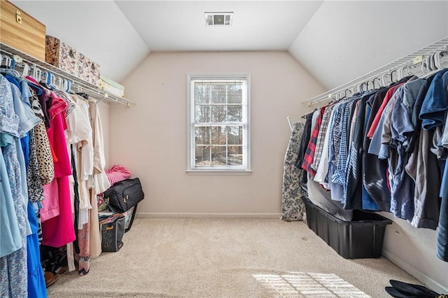 walk in closet featuring vaulted ceiling, visible vents, and carpet floors